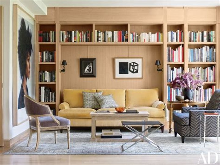 book-lined walls and full bookshelves with staircase and skylights