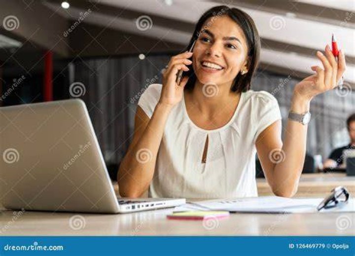 cheerful young beautiful woman using smart phone on bed