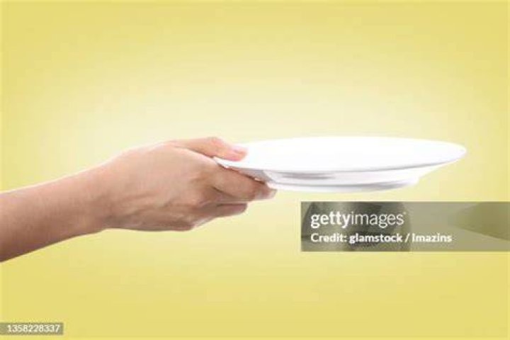 Hand holding a plate with whipped cream Hand holding a plate with whipped cream