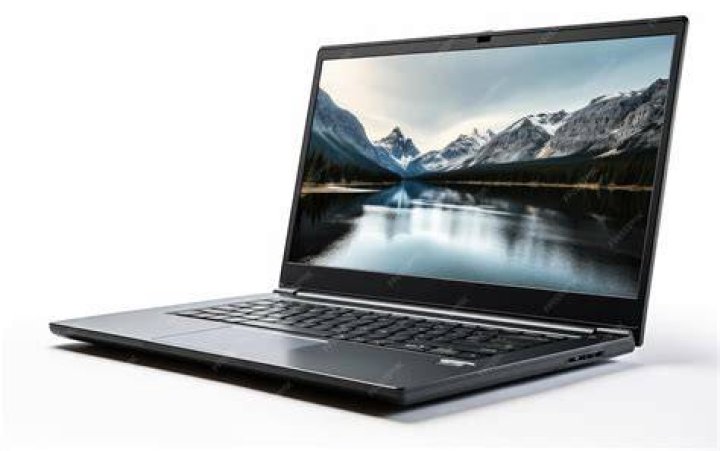 Laptop computer open and piece of paper on a desk