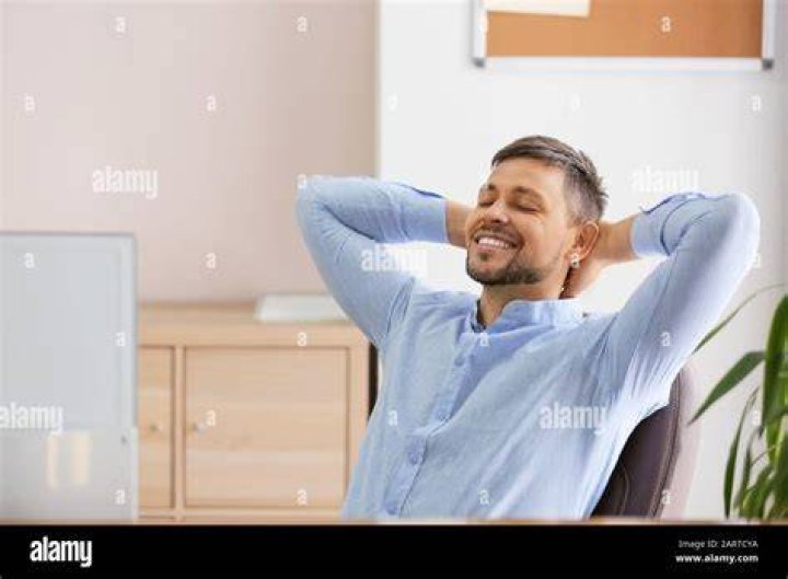 Man having a break from exercising wearing headphones and drinking from bottle man having a break from exercising wearing headphones and drinking from bottle