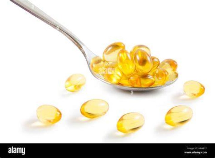 A spoonful of omega-3 vitamins on a blue background omega 3 pills on spoon