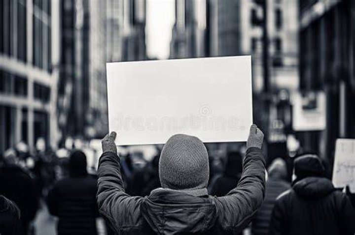 protester holding up a sign that reads &ldquo;Indigenous Justice is Climate Justice&rdquo;