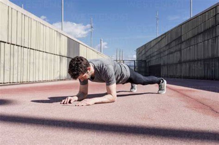Sportive man exercising outdoors between walls Sportive man exercising outdoors between walls