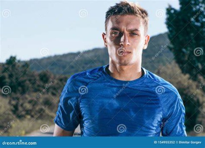 Sweaty male runner running on sunny urban footbridge at sunrise Sweaty male runner running on sunny urban footbridge at sunrise