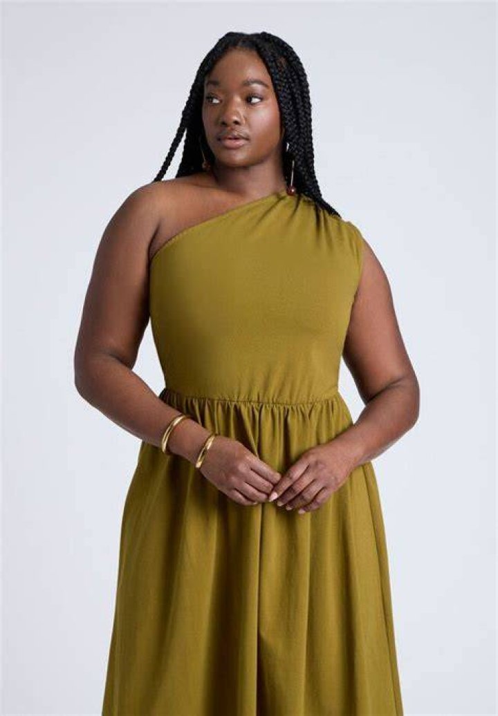 woman wearing eloquii one shoulder dress with slit with one hand on hip
