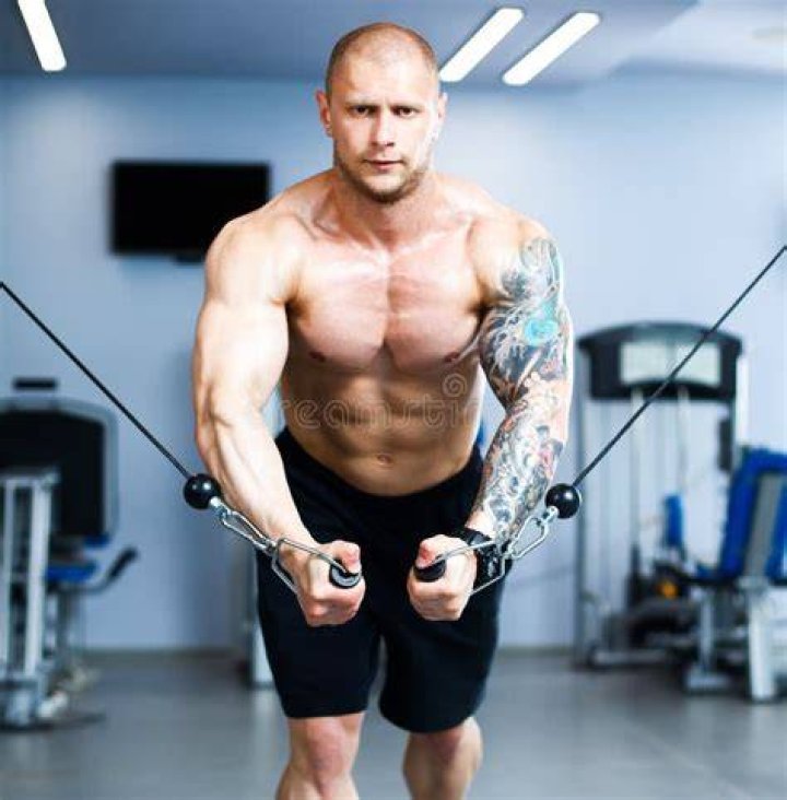 Young Man Training On A Leg Machine In The Gym young man training on a leg machine in the gym
